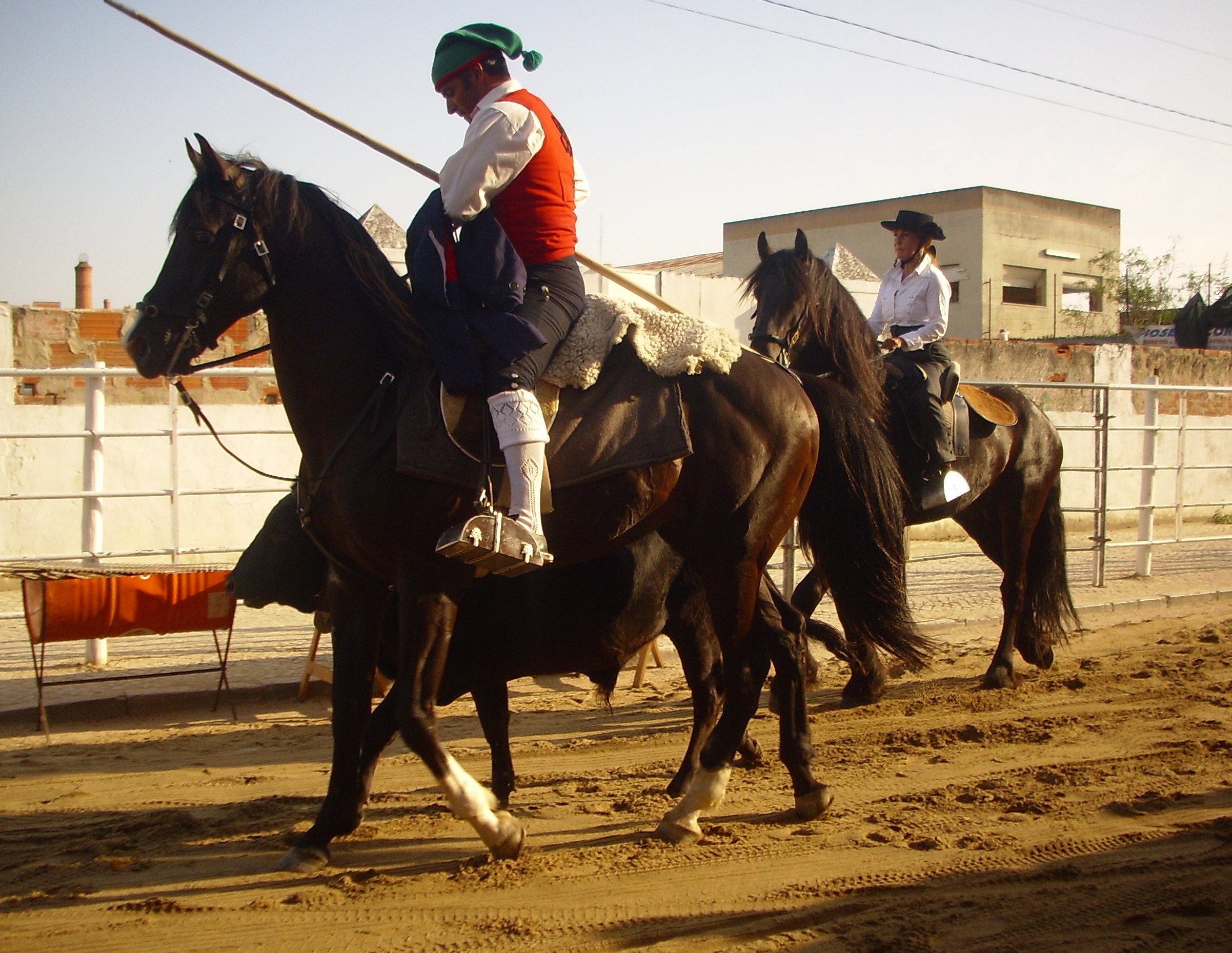 Campino a cavalo, de barrete verde, colete encarnado e pampilho na mão