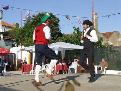 Dois homens a dançar o fandango numa festa, um de barrete de campino
